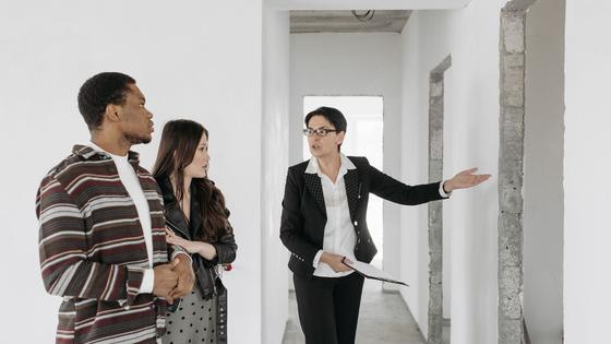 Un agent immobilier avec des clients dans un logement
