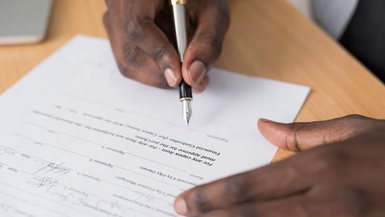 La signature d'un document, gros plan sur les mains